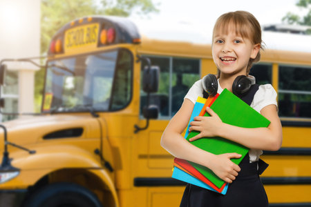 Smiling active excellent best student schoolgirl holding books and going to school wearing bag