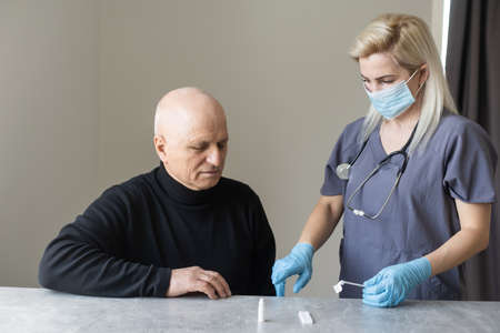doctor talking to her male senior patient at officeの写真素材