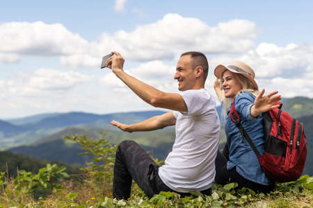 Portrait of beautiful young couple enjoying nature at mountain peak.の写真素材