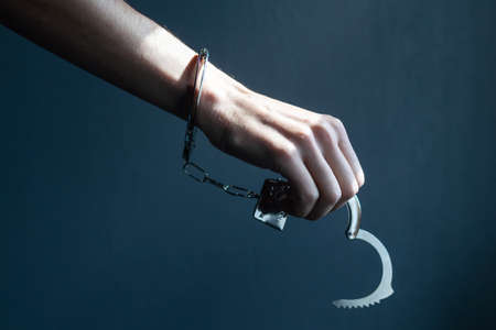 the black handcuffs on wooden background. criminal justiceの写真素材