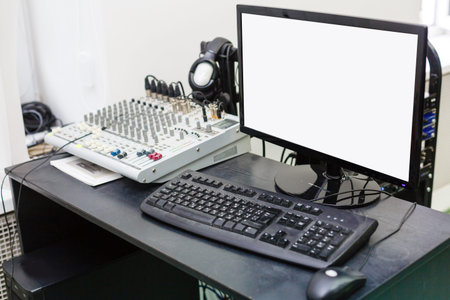 dekstop on a desk. Dark screen, no signal. DJ mixer for playing music, headphones