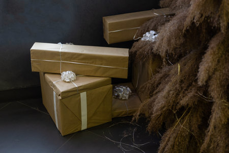 Beautiful Christmas gift boxes on floor near fir tree in room