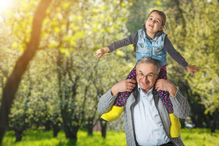Authentic photo of smiling grandfather hugging with his granddaughterの写真素材