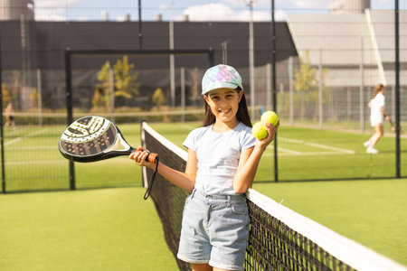 little girl with racket playing padel tennis at courtの写真素材