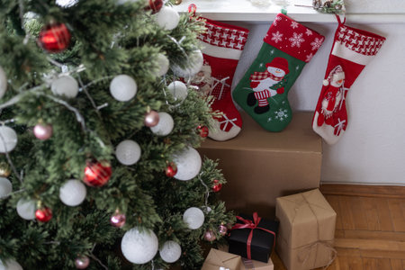 Festive Christmas decorations of a light room with a Christmas tree and knitted socks for Santas giftsの写真素材