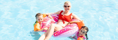 Children playing in pool. Two little girls having fun in the pool. Summer holidays and vacation...