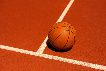 Top view orange ball for basketball lying on the rubber sport court. Sport red ground outdoor in the yardの写真素材