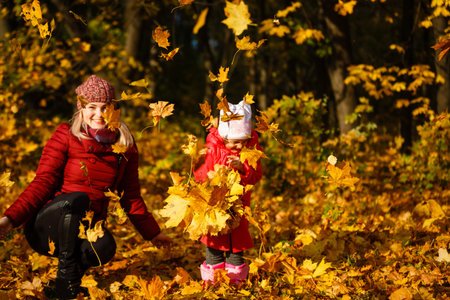 Young mother with her little daughter in an autumn park