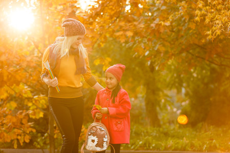 portrait of a young woman and her daughter in the autumn parkの写真素材