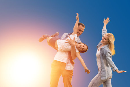 funny young parents mom dad with child kid daughter teen girl isolated on blue background. Family day parenthood conceptの写真素材
