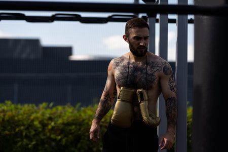 boxer athlete man putting on glove gloves prepared to train outdoors.