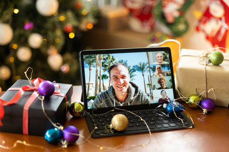 Family video call with kid presenting gift by remote chat digital tablet screen on Merry Christmas table holiday background. Xmas online virtual family party celebration, Happy New Year videocallの写真素材