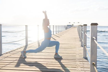 woman exercising on pontoon by the seaの写真素材