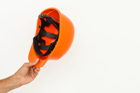 Male Hand with yellow safety helmet. Human Hand holding hard hat, Isolated on White Background