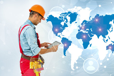 Side view man engineer wearing protective helmet using a tablet computer gadget choosing...