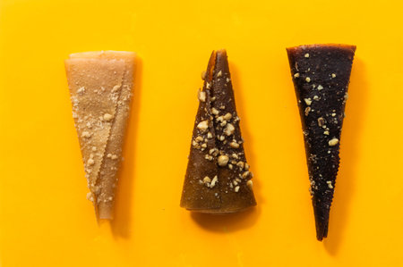Delicious fruit leather rolls on yellow background, flat lay. Space for text