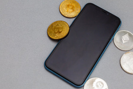 Coin bitcoin with phone on gray backgroundの写真素材
