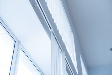 Large window with white roller blinds indoorsの写真素材