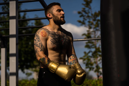 young naked boxer wearing protecting gloves.