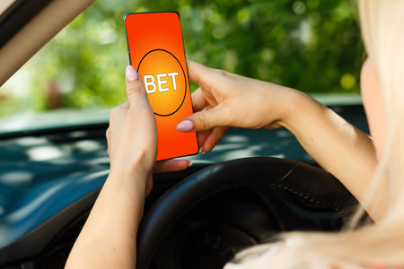 hands of a woman holding a online betting device. All screen graphics are made up.の写真素材
