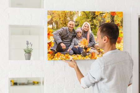 Canvas print with gallery wrap. man hangs autumn photography, photocanvas