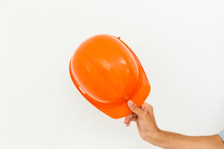 Male Hand with yellow safety helmet. Human Hand holding hard hat, Isolated on White Backgroundの写真素材