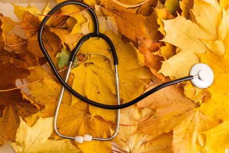 Background image with stethoscope on yellow autumn leavesの写真素材