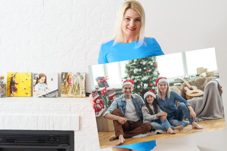 a woman holds a photo of Christmas on a photo canvas.の写真素材