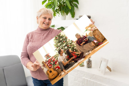 a woman holds a photo of Christmas on a photo canvas.の写真素材