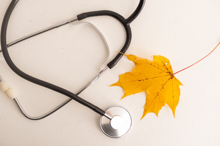 Background image with stethoscope on yellow autumn leavesの写真素材