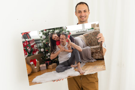 a man holds a Christmas photo on a photo canvasの写真素材