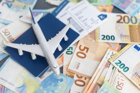 Toy plane on Euro cash background, travel with airplane. Conceptual image of the price of airline tickets for travel. Selective focue, close-up.の写真素材