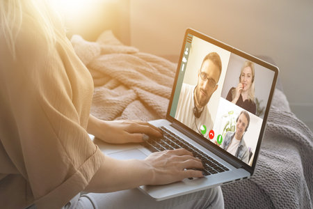 Back view of woman making video call with her doctor while staying at home. Close up of patient in...
