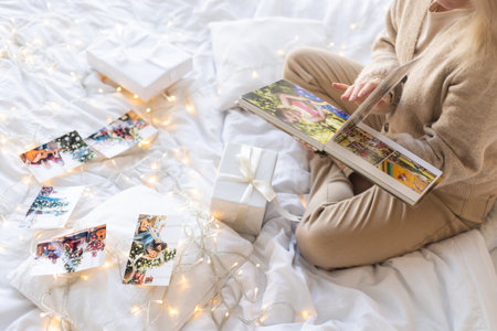 smiling woman with photo album resting at homeの写真素材