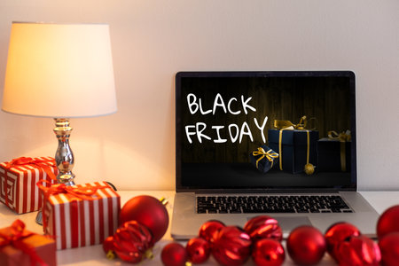 Black Friday shopping concept written in laptops black screen against blurred christmas lights backgroundの写真素材