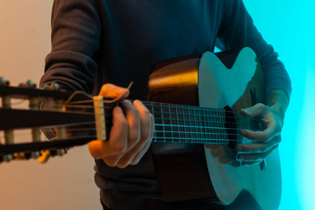 male hands and guitar close-up musician playing acoustic guitar. Music