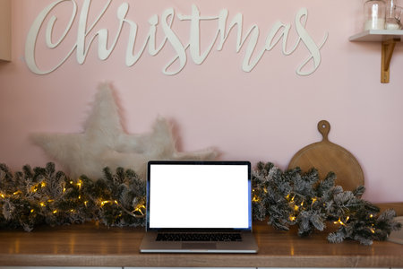 Computer laptop with blank screen in christmas tree winter backgroundsの写真素材