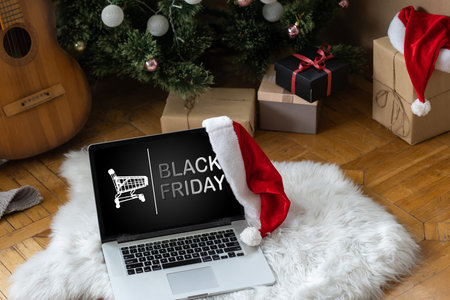 Black Friday concept. Female hand holding a credit card and shopping online through laptop. Computer is surrounded by cardboard boxes with protective foam pads and electronic products inside. Flat layの写真素材