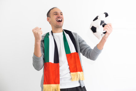 Joyful happy young man in shirt posing background. People sincere emotions lifestyle concept. Mock up copy space. Holding soccer ball doing winner gesture screamingの写真素材