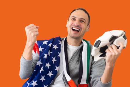male football fan with a crumpled ball and with the flag of the UAE and the USAの写真素材