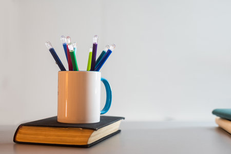 book and a cup with pencilsの写真素材