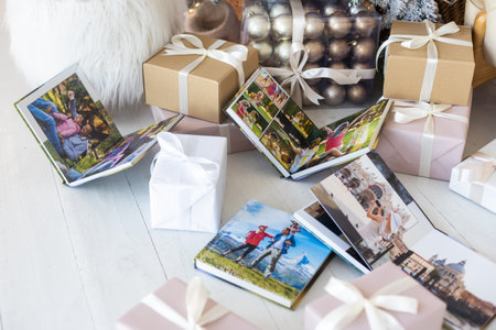 Photo book album under the Christmas tree surrounded by Christmas giftsの写真素材