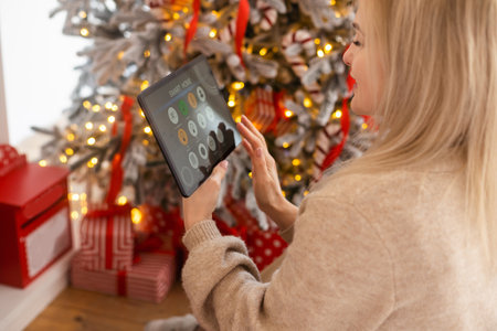 Young woman using application in his smart home at Christmasの写真素材