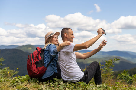 Portrait of beautiful young couple enjoying nature at mountain peak.の写真素材
