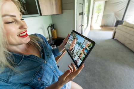 Close up of female hand holding tablet having video chat with colleagues. Woman watch online business webinar on digital tabletの写真素材