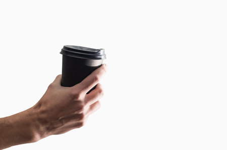 Hand holding a mug, Paper Coffee Cup with delicious coffee in a cafe on a white background, mock up,...