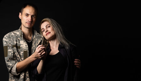 military man and his wife on a black background