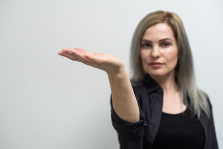 Happy female pointing or indicate something on the left side isolated on white.の写真素材