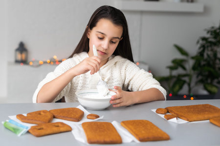 Kids baking Christmas gingerbread house. Children celebrating winter holiday at home. Decorated...