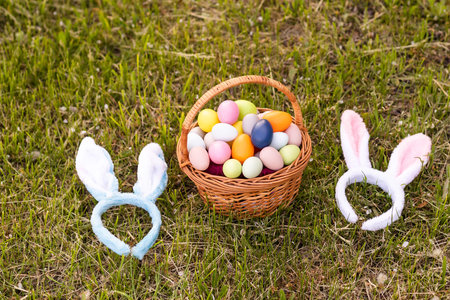 painted Easter eggs in basket on grass. Traditional decoration in sun light